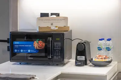 a microwave sitting on top of a counter with a phone at Luxury 2BR Burj View & Jacuzzi in Dubai