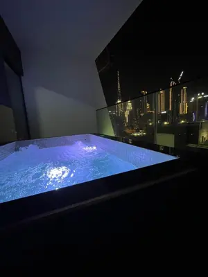 a hot tub in a room with a view of the city at Luxury 2BR Burj View & Jacuzzi in Dubai