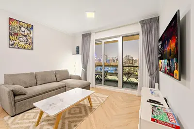 a living room with a couch and a large window at Luxe 1BR in Fairways East with Canal Views in Dubai