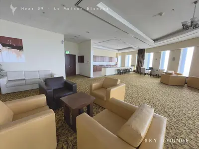 a waiting room with couches and chairs and a table at Huzz 59 - La Maison Blanche in Dubai