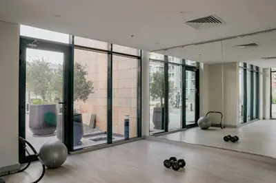 an empty room with a gym with large windows at Cozy Studio with Garden Views in Nad Al Sheba in Dubai
