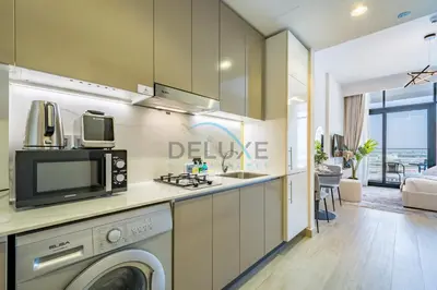 a kitchen with a washing machine and a microwave at Cozy Studio in Azizi Riviera 3, Al Merkadh by Deluxe Holiday Homes in Dubai