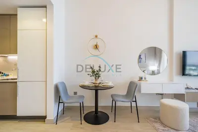 a dining room with a table and two chairs at Cozy Studio in Azizi Riviera 3, Al Merkadh by Deluxe Holiday Homes in Dubai