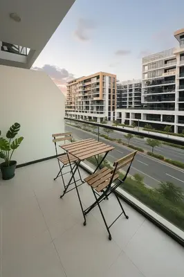 a table and chairs on a balcony with a view of a city at Special Offer Rental Studio at Azizi Riviera Dubai in Dubai