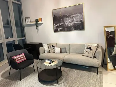 a living room with a couch and a table and chairs at Cozy 1BHK Apartment-Dubai Marina in Dubai