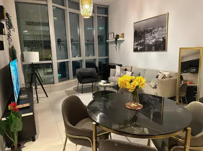 a living room with a glass table and chairs at Cozy 1BHK Apartment-Dubai Marina in Dubai