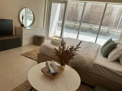 a bedroom with a bed and a table and a tv at Luxury Studio Near Burj Khalifa in Dubai