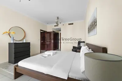 a bedroom with a white bed and a mirror at High-floor 2BR at Palladium, JLT - Near Metro in Dubai
