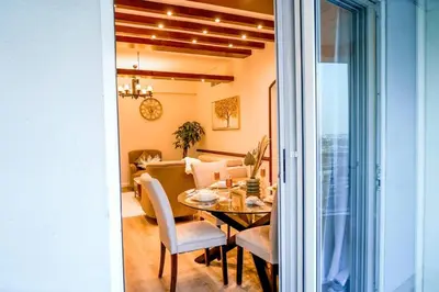 a dining room and living room with a table and chairs at The Nest by Beds & Company in Dubai