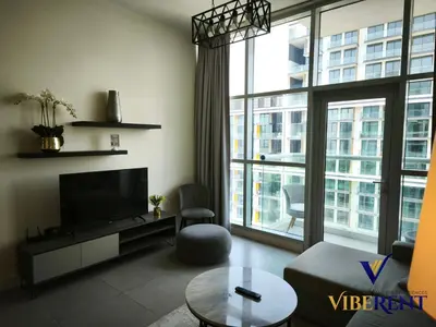 a living room with a tv and a large window at La Riviera Serenity in Dubai