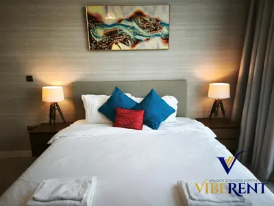 a bedroom with a white bed with blue and red pillows at La Riviera Serenity in Dubai