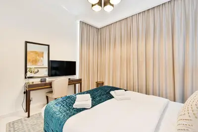 a hotel room with a bed and a desk at Urban Sanctuary Studio with Pool, Gym and Playground in Dubai