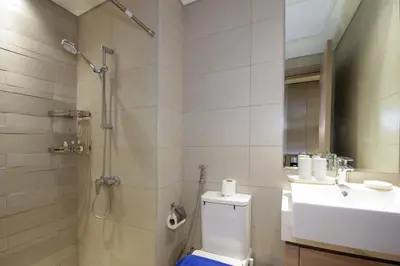 a bathroom with a shower and a toilet and a sink at NewArabian Azizi Riviera Studio in Dubai