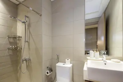 a bathroom with a shower and a toilet and a sink at NewArabian Azizi Riviera Studio in Dubai
