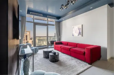 a living room with a red couch and a large window at Stunning Burj Khalifa View 5 Star Hotel Amenities in Dubai