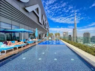 a pool on the roof of a building with people laying on it at Stunning Burj Khalifa View 5 Star Hotel Amenities in Dubai