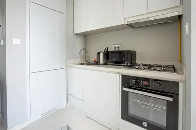 a kitchen with white cabinets and a stove top oven at Dubai Burj KHALIFA VIEW SMART HOME ZADA TOWER in Dubai