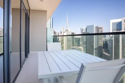 a white bench on a balcony with a view of the city at Dubai Burj KHALIFA VIEW SMART HOME ZADA TOWER in Dubai