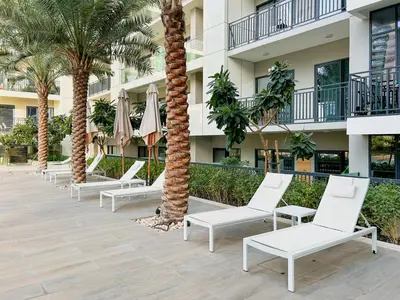 a row of chairs and palm trees in front of a building at Dubai Burj KHALIFA VIEW SMART HOME ZADA TOWER in Dubai