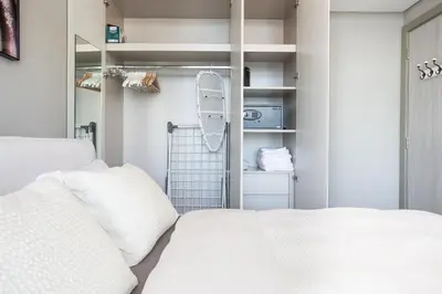 a bedroom with a white bed with white pillows at Dubai Burj KHALIFA VIEW SMART HOME ZADA TOWER in Dubai
