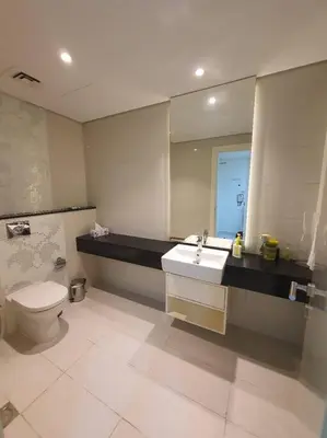 a bathroom with a toilet and a sink and a mirror at damac maison canal view Luxuary 1BHK in heart downtow in Dubai