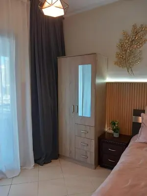 a bedroom with a dresser and a cabinet with a mirror at Cosy Studio Marina in Dubai
