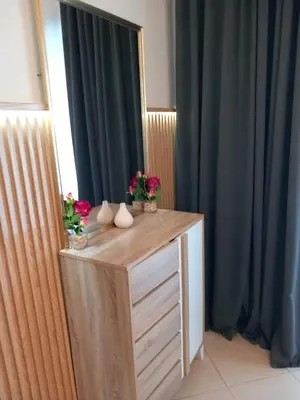 a wooden dresser with flowers on top of it at Cosy Studio Marina in Dubai