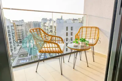 two chairs and a table on a balcony at Bloomfields Modern Stu In Azizi Riviera in Dubai