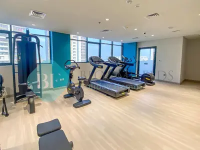 a gym with treadmills and ellipticals in a building at Bloomfields Modern Stu In Azizi Riviera in Dubai