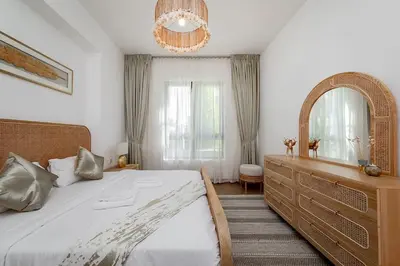 a bedroom with a large bed with a dresser and a mirror at La Mer 1bedroom Private Beach in Dubai