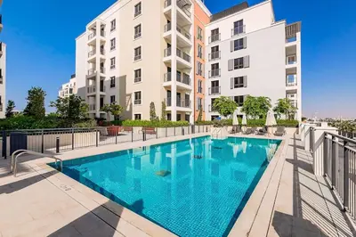 a swimming pool in front of a building at La Mer 1bedroom Private Beach in Dubai