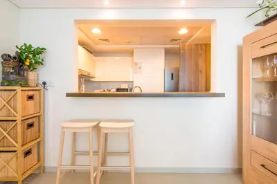 a kitchen with two bar stools and a counter at Al Bateen Residences, JBR- Stunning 2-BR Apartment with Sea View in Dubai