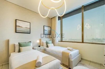 two beds in a room with a large window at Stylish 2BR in Sky Gardens, DIFC by Deluxe Holiday Homes in Dubai