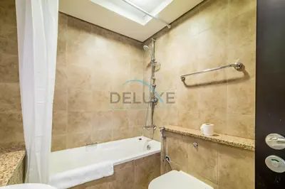 a bathroom with a toilet and a bath tub at Stylish 2BR in Sky Gardens, DIFC by Deluxe Holiday Homes in Dubai
