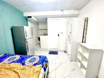 a room with a bed and a refrigerator at Flat in Dubai Al Karama in Dubai
