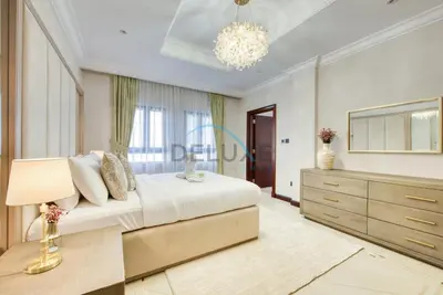 a bedroom with a bed and a dresser and a chandelier at Immaculate 4BR Villa with Assistant Room and Private Pool at Frond O Palm Jumeirah by Deluxe Holiday Homes in Dubai