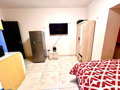 a room with a refrigerator and a tv on the wall at Flats in Dubai Emirates Tower Metro Station in Dubai