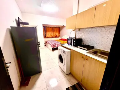 a kitchen with a refrigerator and a washing machine at Flats in Dubai Emirates Tower Metro Station in Dubai