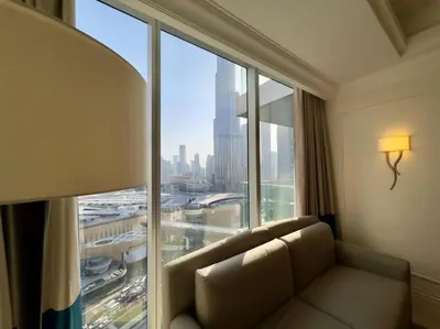 a living room with a couch in front of a large window at ElevenSisters in Dubai