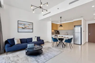 a living room with a blue couch and a table at Luxe Living in 1 Bedroom apartment at 17 Icon Bay in Dubai