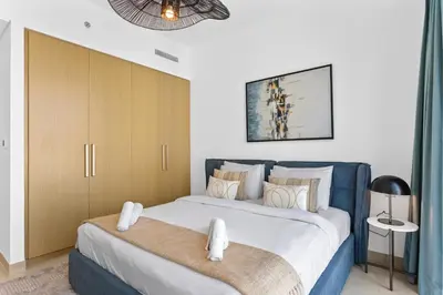 a bedroom with a large bed with two towels at Luxe Living in 1 Bedroom apartment at 17 Icon Bay in Dubai