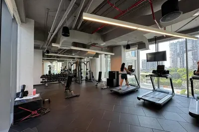 a woman running on a treadmill in a gym at Luxe Living in 1 Bedroom apartment at 17 Icon Bay in Dubai