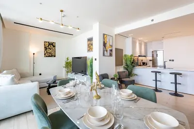 a dining room and living room with a table and chairs at Spacious 2 Bedroom in JVC with pool & gym access in Dubai