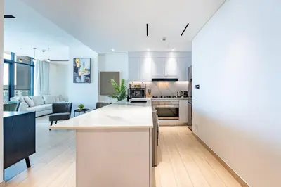 an open kitchen and living room with white walls at Spacious 2 Bedroom in JVC with pool & gym access in Dubai