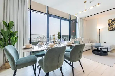 a dining room with a table and chairs and a couch at Spacious 2 Bedroom in JVC with pool & gym access in Dubai