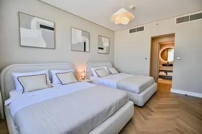 a bedroom with two beds and a couch in it at Casa Bouclé An Urban sanctuary in DIFC 1BR in Dubai