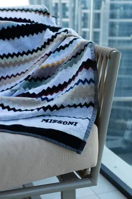 a blanket sitting on top of a chair at Lusso Hometels Missoni Business Bay in Dubai