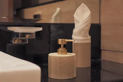 a white soap dispenser sitting on top of a counter at Lusso Hometels Missoni Business Bay in Dubai