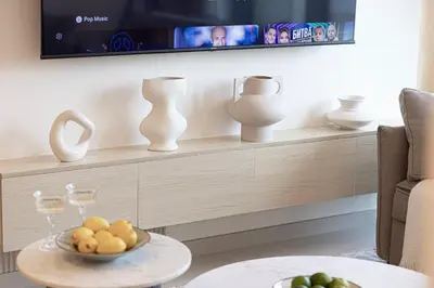 a living room with a tv and a table with a bowl of fruit at BURJ ROYALE - Luxurious Two-Bedroom apartment in DOWNTOWN, Burj Khalifa view POOL in the building, 5-min walk to Dubai Mall & Dubai Fountains in Dubai