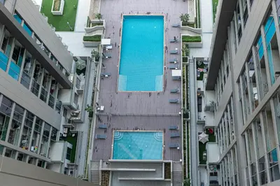 an overhead view of a building with a swimming pool at Modern 1br Oasis in Sobha Creek Vista A, MBR City - Allsopp & Allsopp in Dubai
